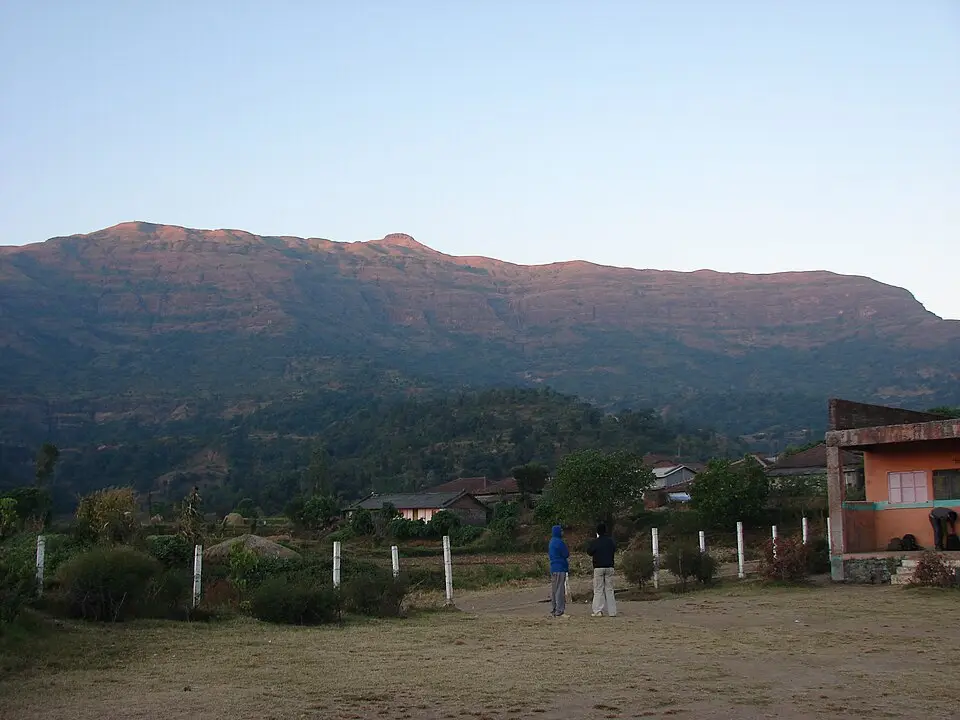 Kalsubai peak rising above farm fields